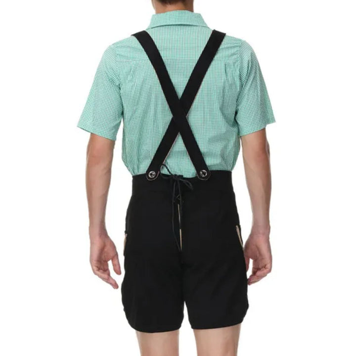 Mann in grüner Trachtenhemd und schwarzer Lederhose mit Hosenträgern, Rückansicht.