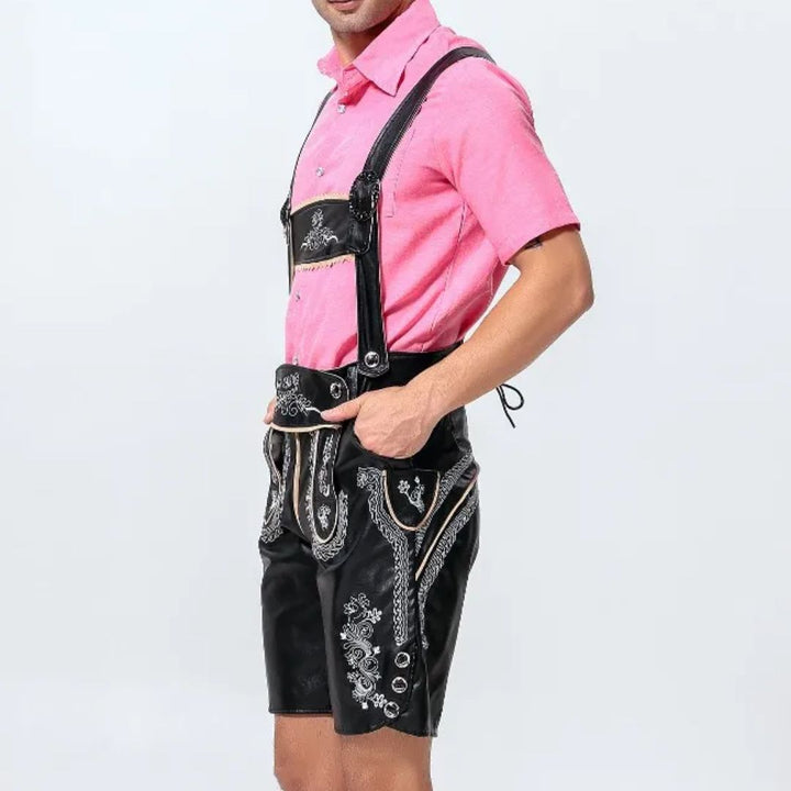 Mann in traditioneller schwarzer Lederhose mit rosa Hemd, bayerische Tracht, Stickereien.