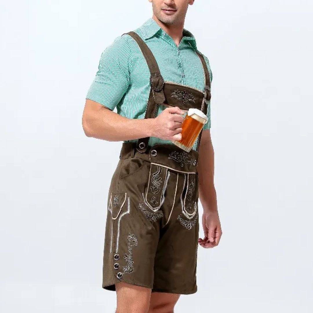 Mann in brauner Lederhose mit Bierkrug, grünem Hemd, traditionelles bayerisches Outfit.