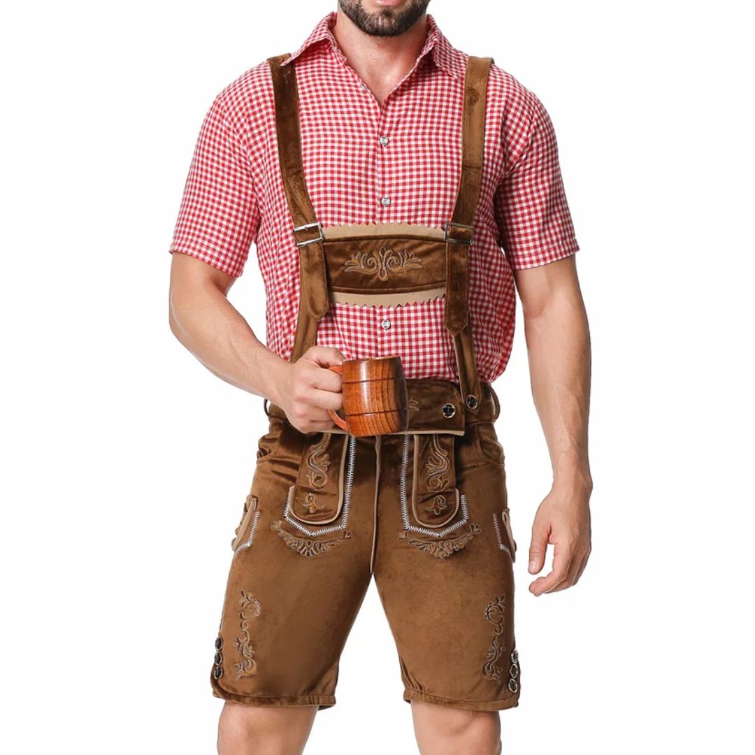 Mann in Lederhose und rot-weiß kariertem Hemd hält Bierkrug. Traditionelle bayerische Tracht.