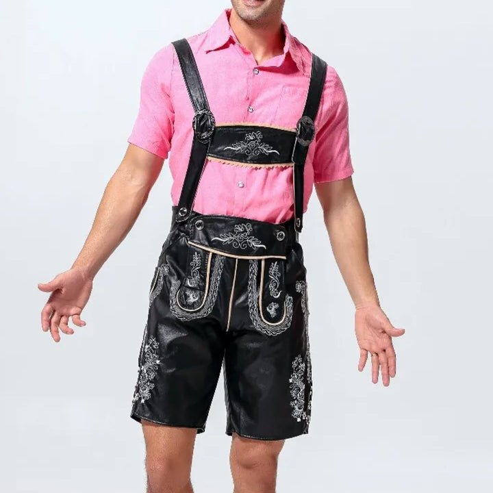 Mann in schwarzer Lederhose mit Stickerei, rosa Hemd, traditionelles bayerisches Outfit.