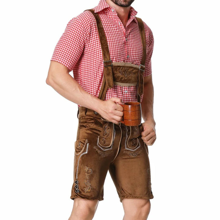 Mann in brauner Lederhose und rotem Karohemd, hält Bierkrug, traditionelles Oktoberfest-Outfit.