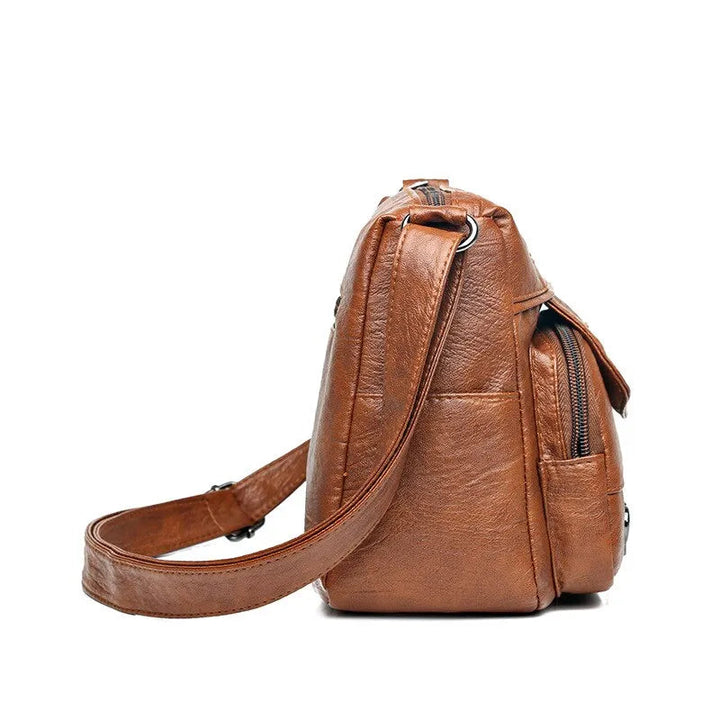 Brauner Leder-Rucksack seitlich, modisch, mit verstellbaren Trägern, ideal für Reisen.