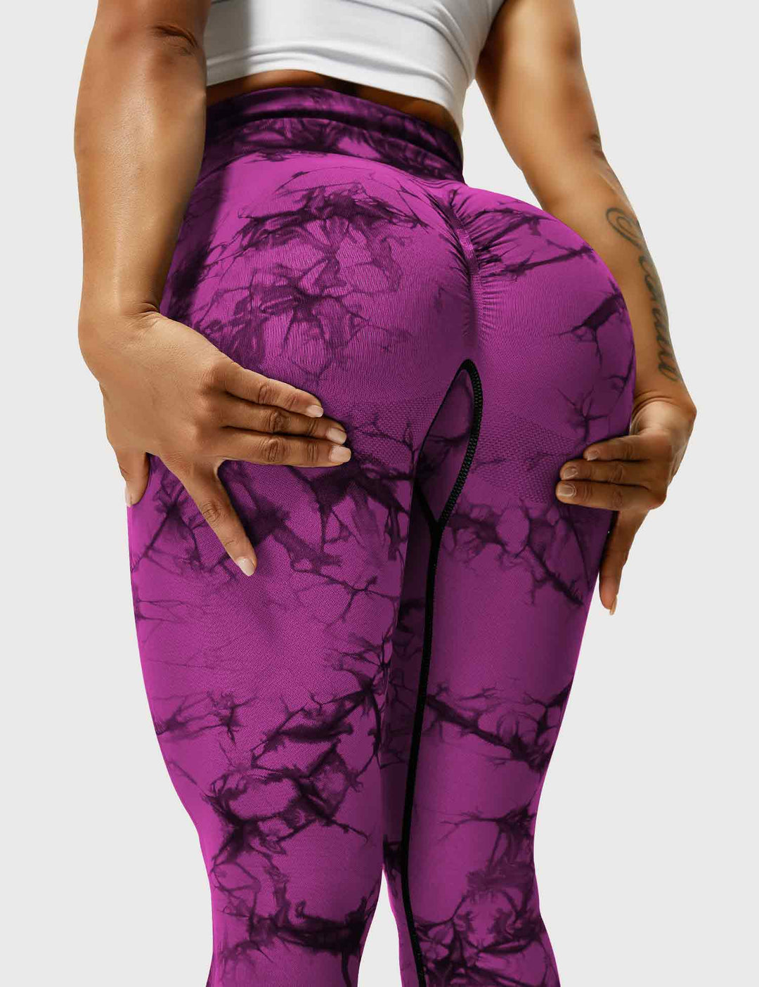 Frau in lila-pinken Leggings mit Marmormuster, Sportbekleidung, Fitnessmode.