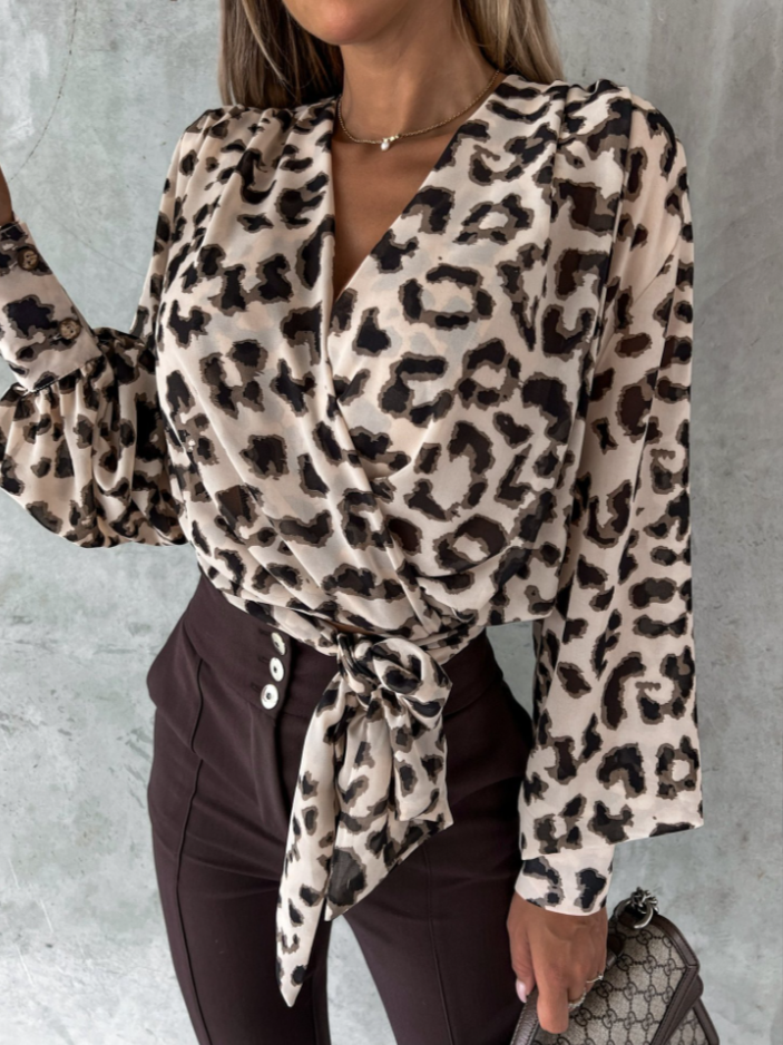 Frau in Leopardenbluse, Wickeldesign, braune Hose, modisch, elegant, Damenmode, Accessoire.