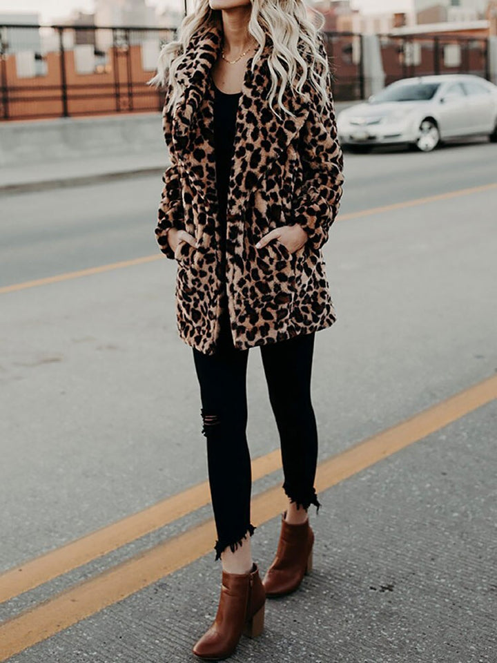 Frau in Leopardenmantel, schwarze Jeans, braune Stiefeletten, Stadtstraße, modisch, Herbstlook.