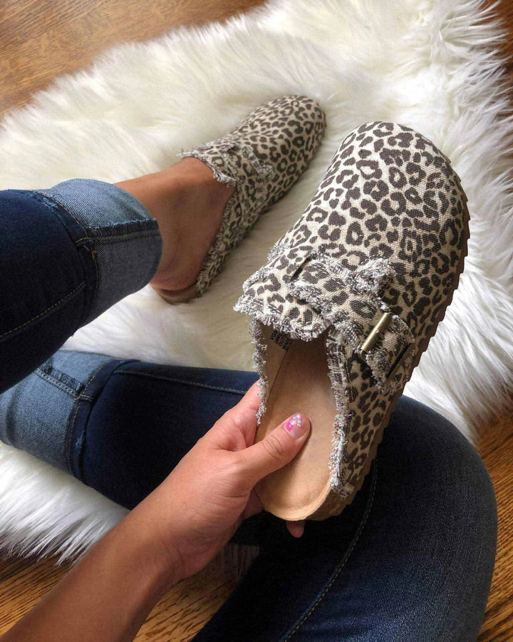 Leopardenmuster Hausschuhe mit Schnalle, Damenmode, gemütlich, auf weißem Teppich.