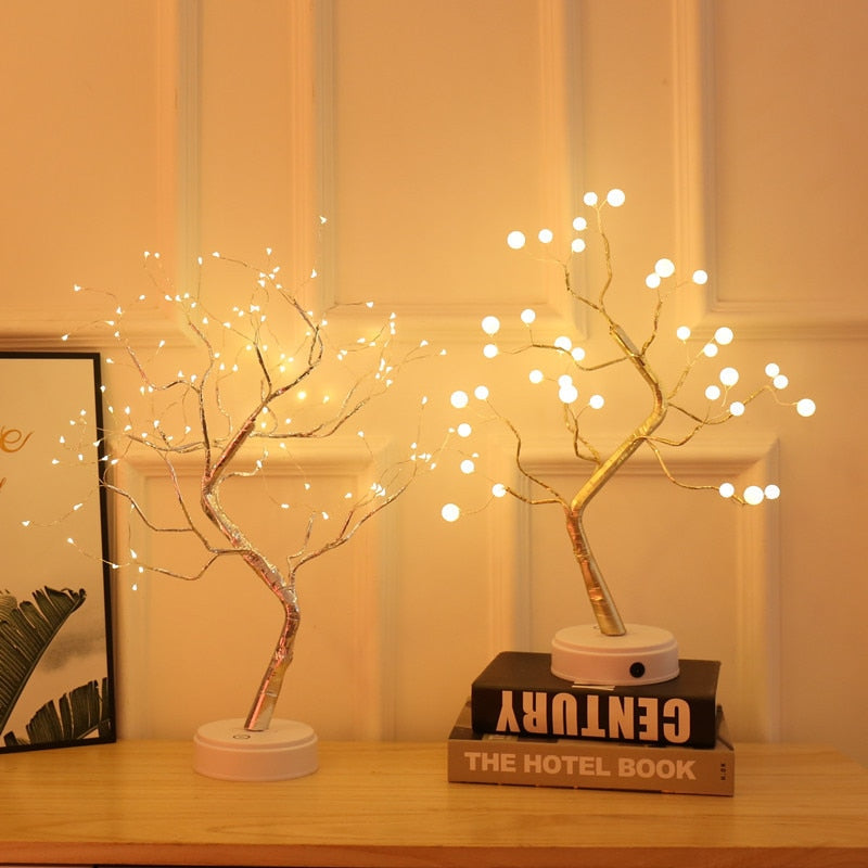 Zwei LED-Baum-Lampen auf Tisch, warmweißes Licht, dekorativ, modernes Design.