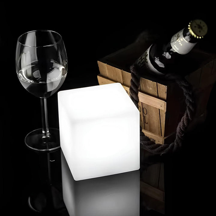 Leuchtender LED-Würfel, Weinglas, Holzkiste mit Flasche, stilvolle Dekoration, Nachtlicht.