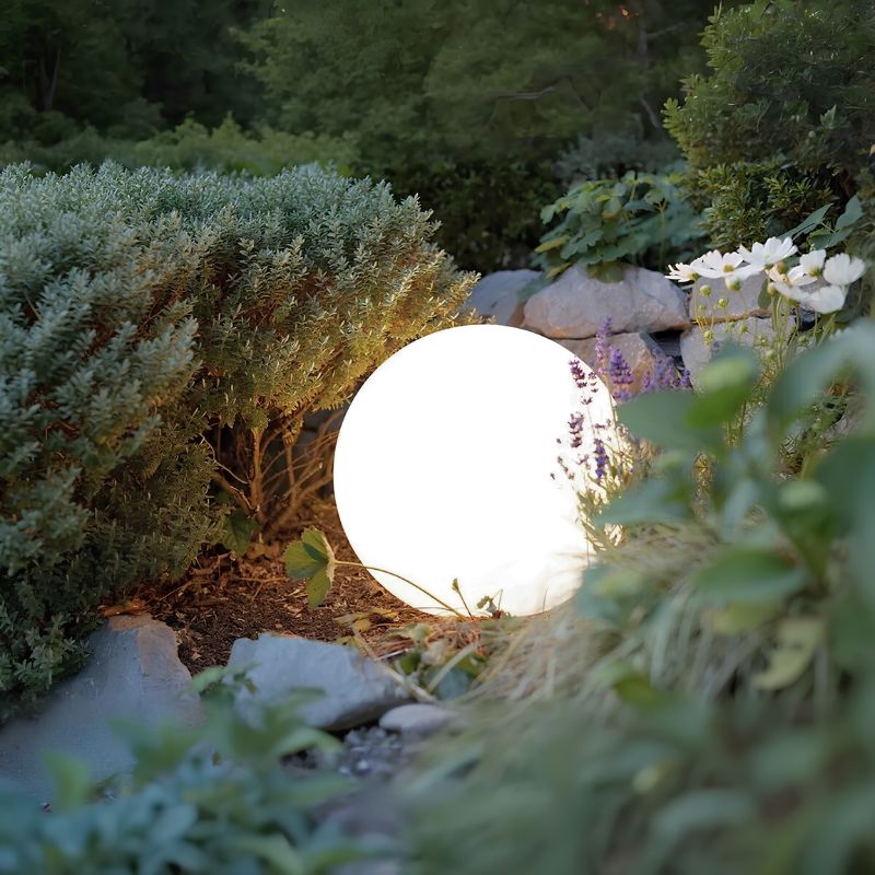 Leuchtende Gartenkugel, LED, rund, weiß, zwischen Pflanzen, stimmungsvolle Außenbeleuchtung.