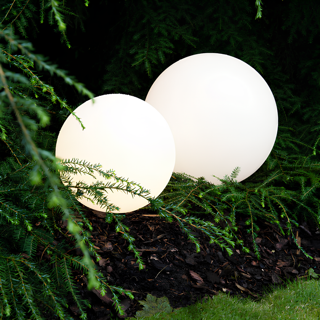 Zwei leuchtende Gartenkugeln, weiß, LED, dekorative Außenbeleuchtung, im Grünen platziert.