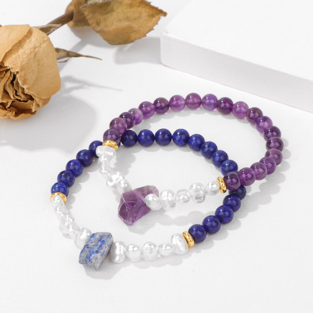 Zwei Armbänder aus Amethyst und Lapislazuli mit Perlen auf weißem Hintergrund.