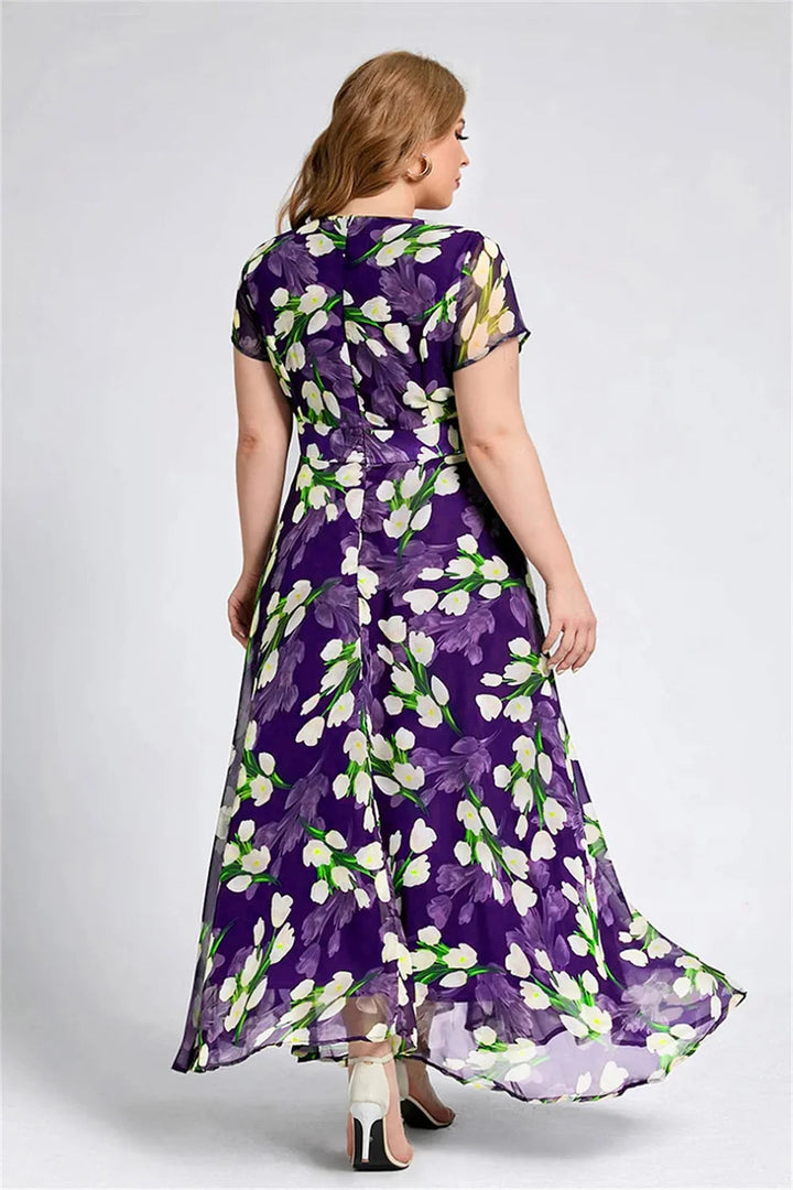 Frau im lila Blumenkleid, knöchellang, kurzärmelig, aus Chiffon, Rückansicht.