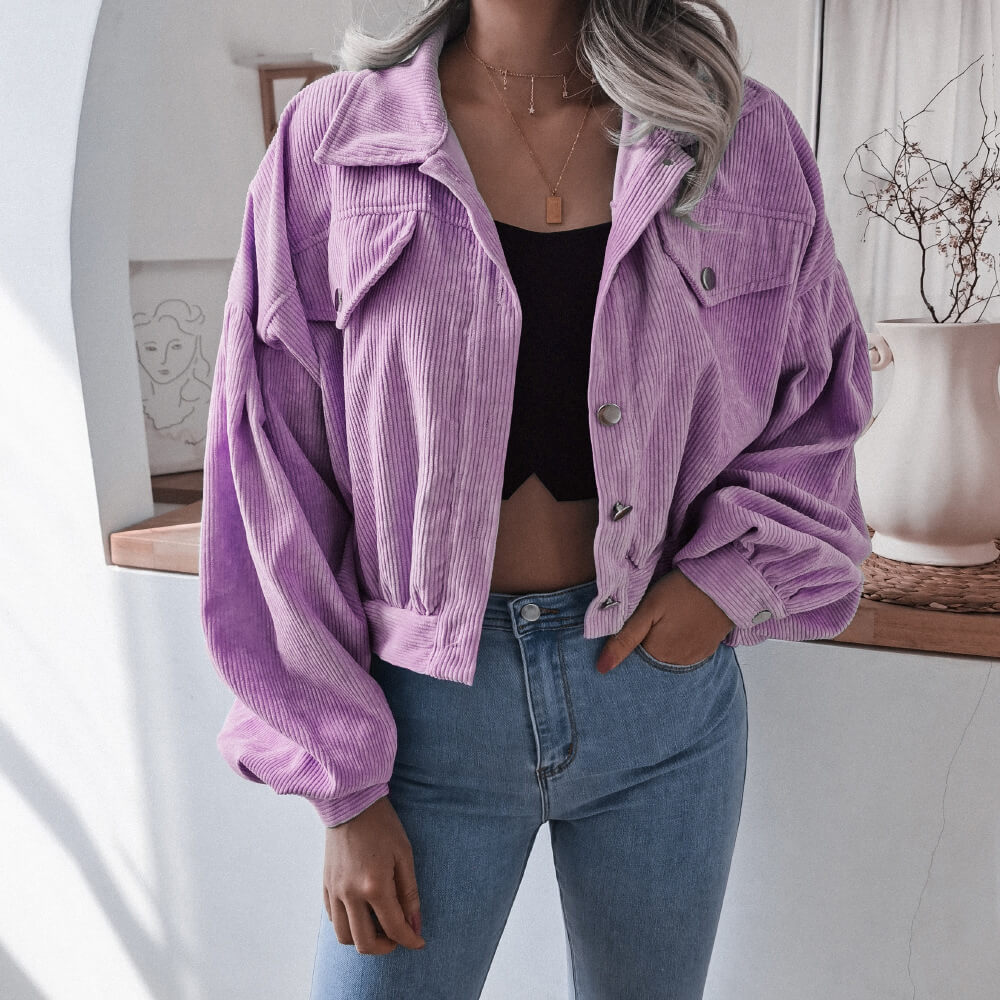 Frau in lila Cordjacke, schwarze Bluse, blaue Jeans, modisch, lässig, Damenmode.