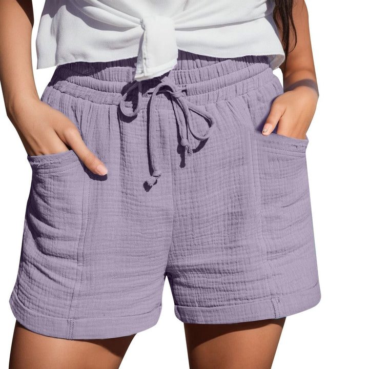 Frau trägt lila Baumwollshorts mit Taschen und Kordelzug, Sommermode, Freizeitkleidung.