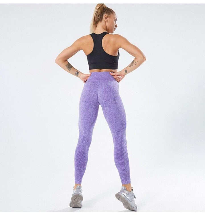 Frau in lila Leggings und schwarzem Sport-BH, Fitnessmode, Sportbekleidung für Damen.