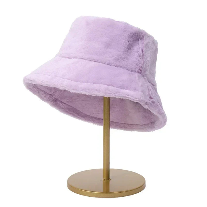 Lila Plüsch-Bucket-Hut auf goldenem Ständer, modisches Accessoire, Wintermode.