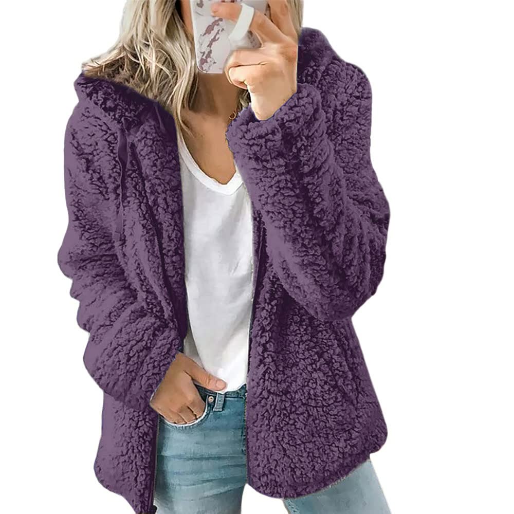 Frau in lila Teddyfelljacke, weißem T-Shirt und Jeans, modische Winterbekleidung.