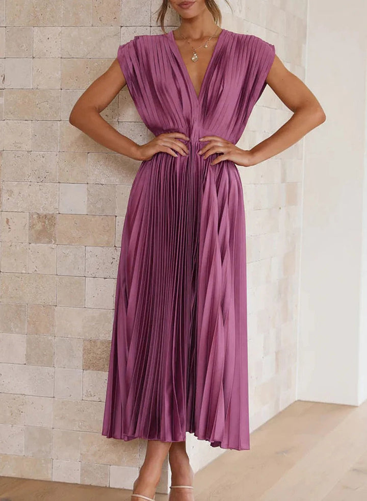 Frau in lila plissiertem Kleid, ärmellos, elegantes Design, Mode, Abendkleid, Innenraum.