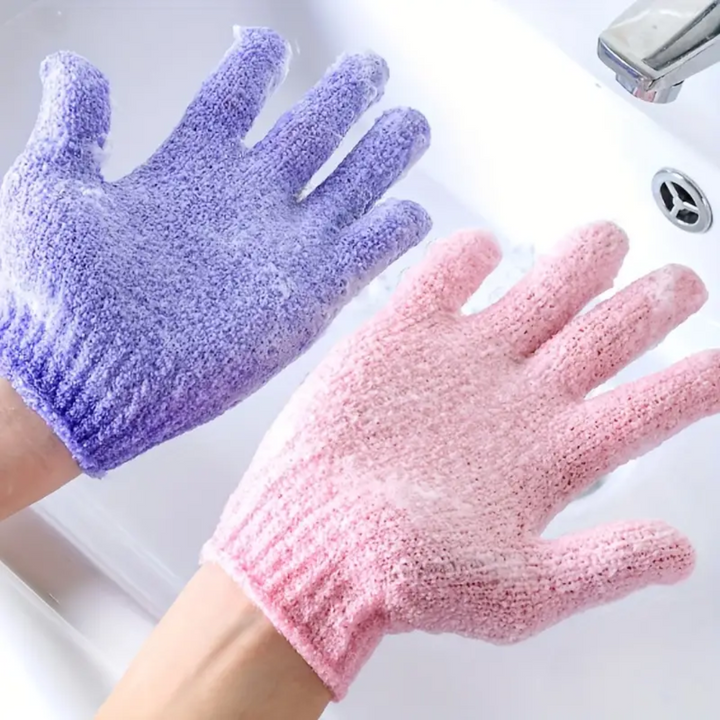 Lila und rosa Peeling-Handschuhe aus Stoff beim Händewaschen im Waschbecken.
