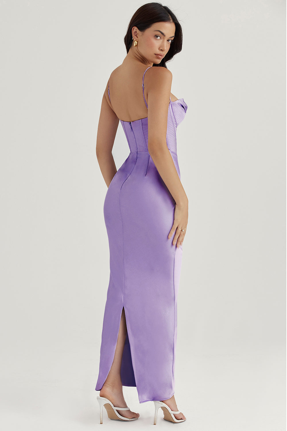 Frau in lila Satin-Abendkleid mit Spaghettiträgern, Rückenausschnitt, elegantes Design.