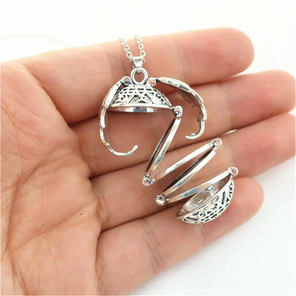 Silberner Medaillon-Anhänger, filigranes Design, geöffnet, auf Handfläche, Schmuck für Damen.