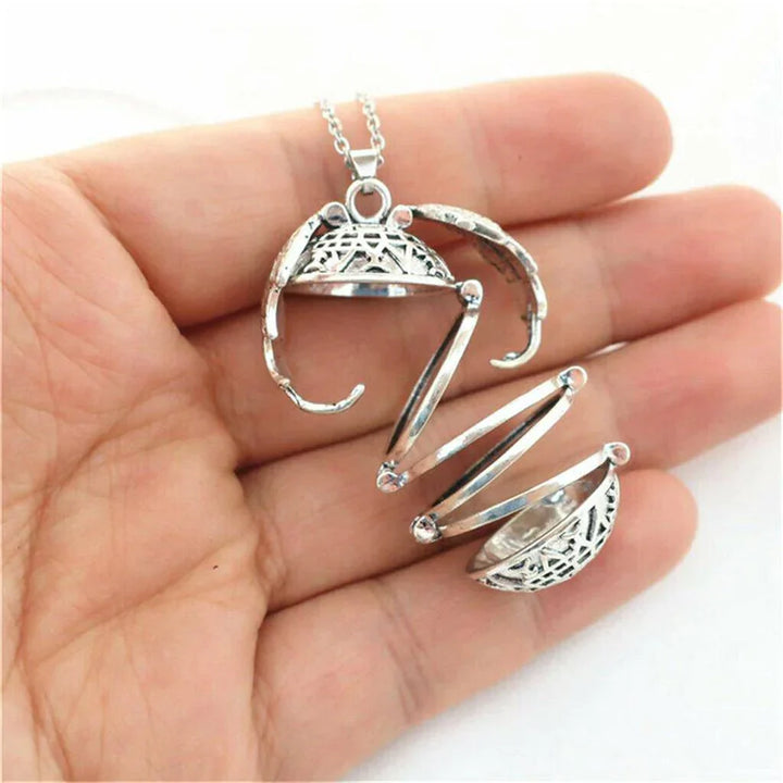 Silberner Medaillon-Anhänger, filigranes Design, geöffnet, auf Handfläche, Schmuck für Damen.
