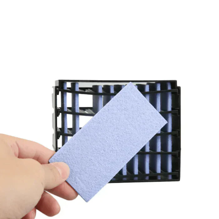 Hand hält blauen Filtereinsatz vor schwarzem Kunststofffilter für Luftreiniger.