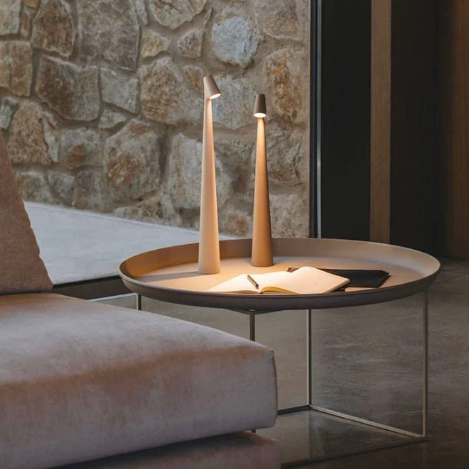 Moderne tragbare Tischlampe, konisch, beige, auf rundem Tisch, neben Sofa, Innenraum.