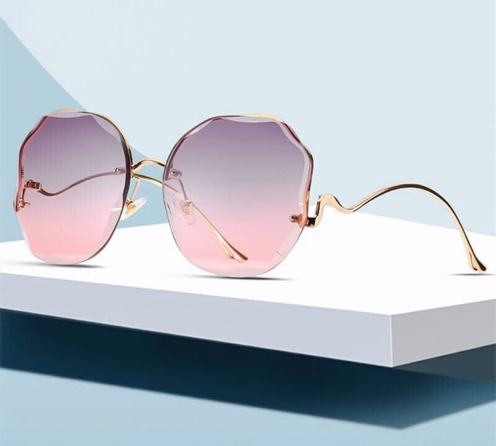 Luxus-Sonnenbrille mit Farbverlauf, runde Gläser, goldene Bügel, modisches Accessoire.