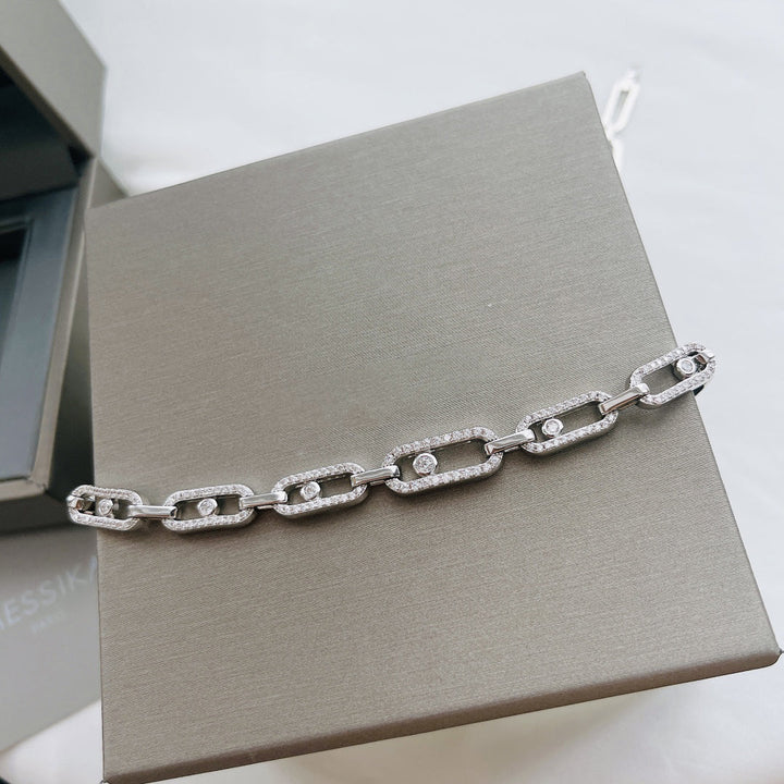 Luxuriöse silberne Halskette mit rechteckigen Gliedern und Diamantakzenten auf grauem Hintergrund.