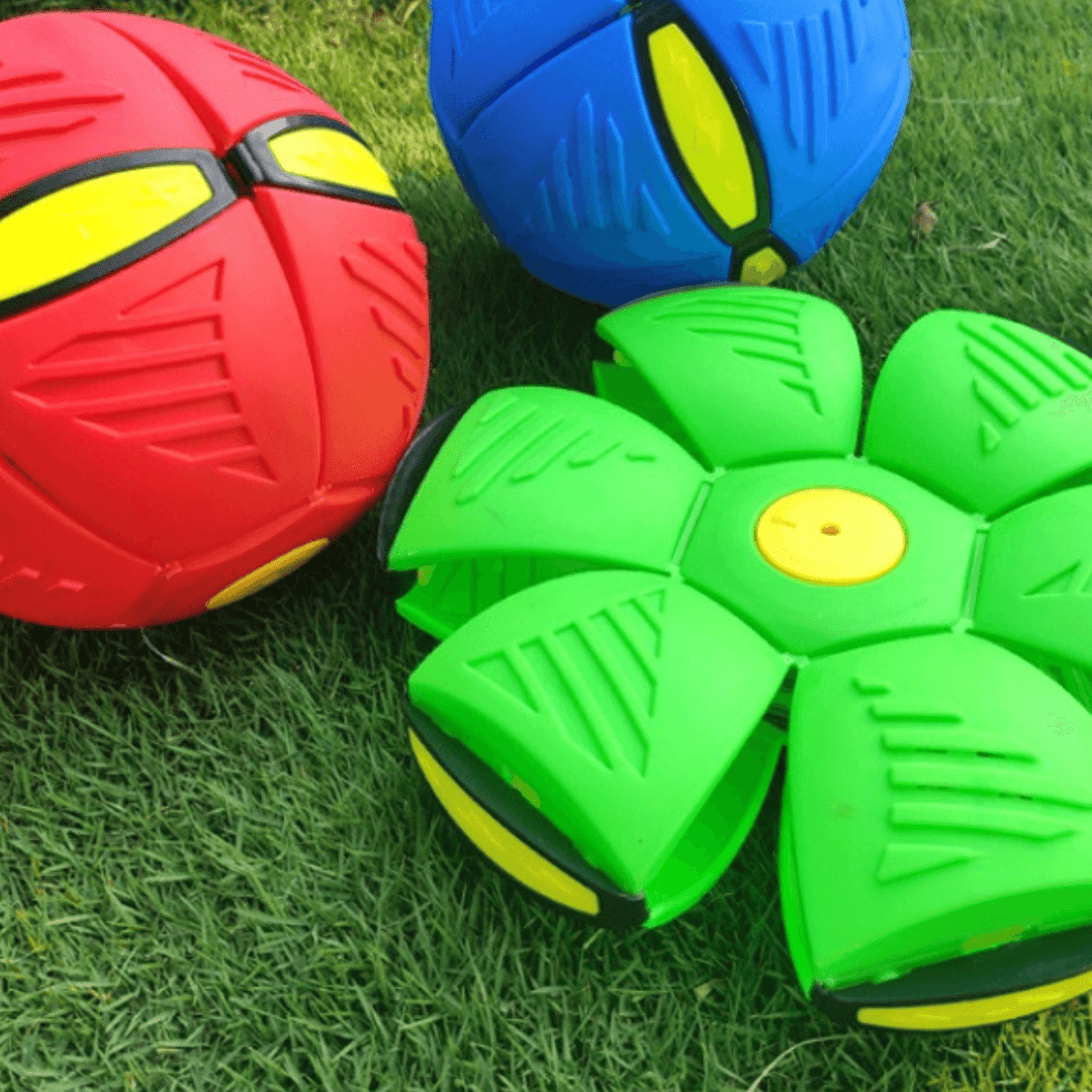 Rote, blaue und grüne fliegende Untertassen-Bälle auf Gras, Spielzeug für Kinder.