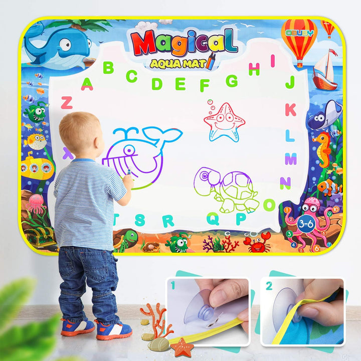Kleinkind malt auf magischer Aqua-Malmatte, bunte Buchstaben, pädagogisches Spielzeug.