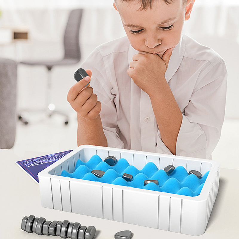 Junge spielt mit Magnetspielzeug auf blauem Schaumstoff in weißer Box, Lernspielzeug.