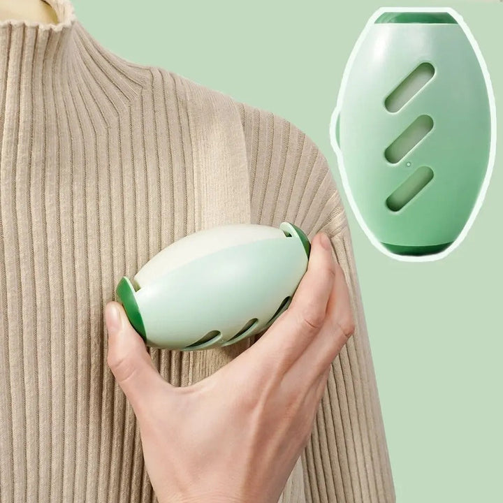 Grüner tragbarer Massagegerät, ergonomisch, für Schulterentspannung, auf beigem Pullover.