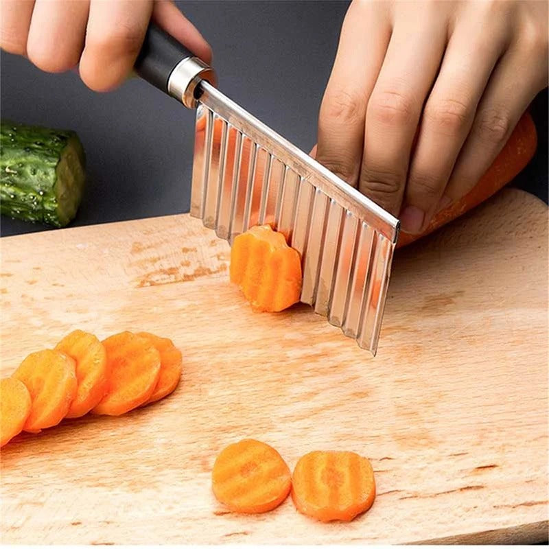 Person schneidet Karotten mit gewelltem Edelstahlmesser auf Holzbrett, Küchengerät, Gemüse.