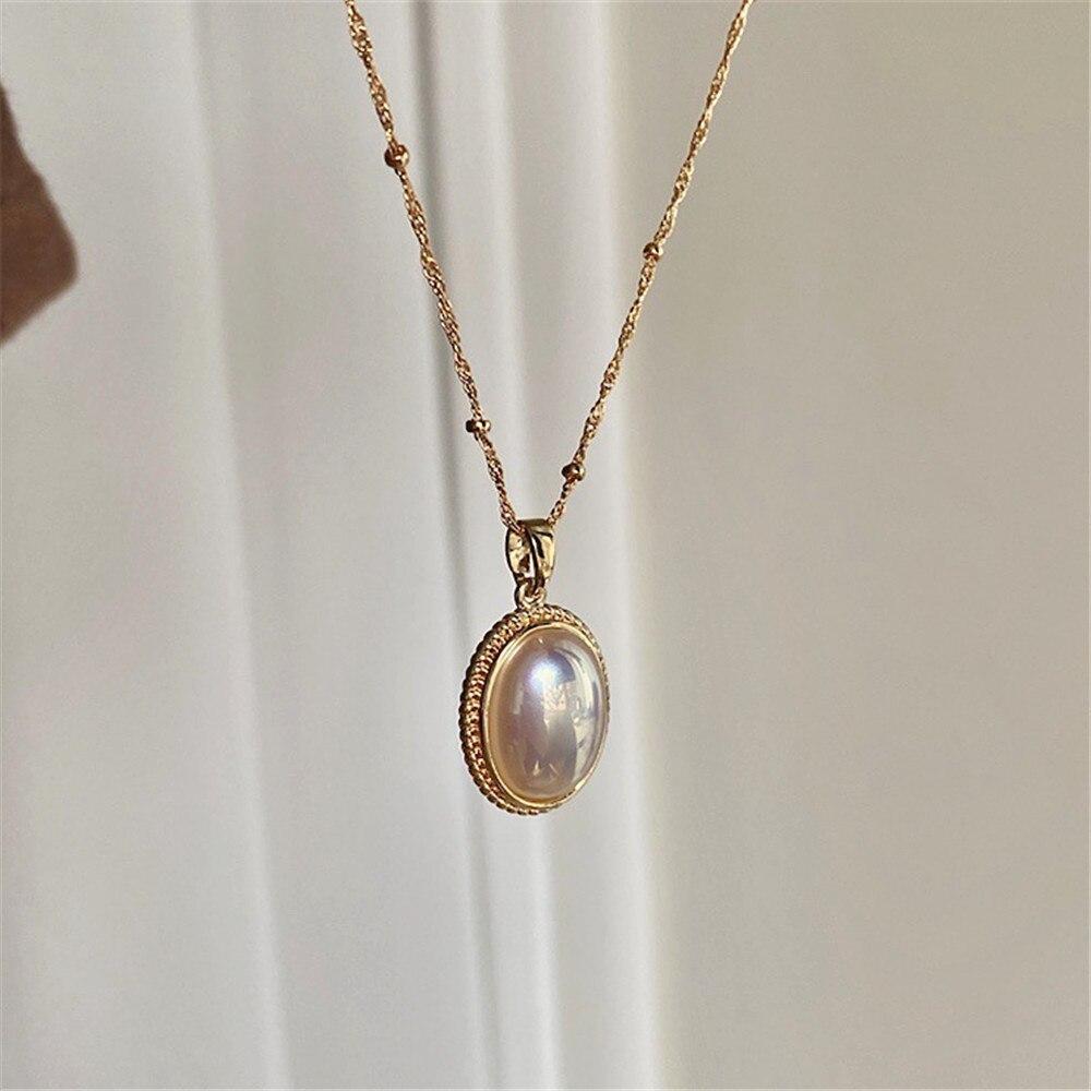 Goldene Halskette mit ovalem Perlenanhänger, vintage, handgefertigt, eleganter Schmuck.