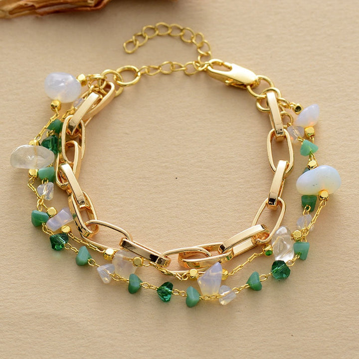 Goldene Kettenarmbänder mit grünen und weißen Edelsteinen, Damen- und Herrenschmuck.