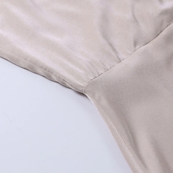 Beigefarbenes Seidenkleid, Nahaufnahme, weicher Stoff, elegante Mode, Damenbekleidung.