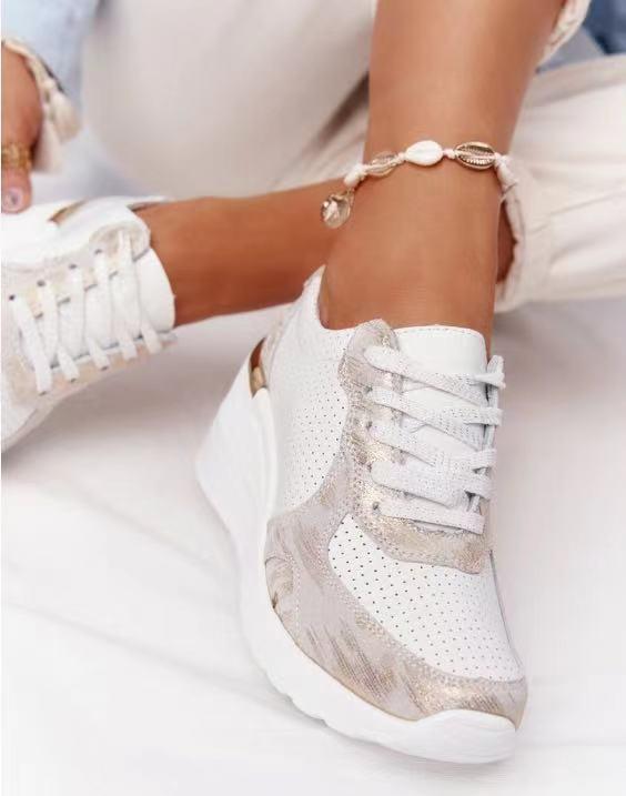 Weiße Damen-Sneaker mit Keilabsatz, perforiertem Design und goldenen Akzenten.