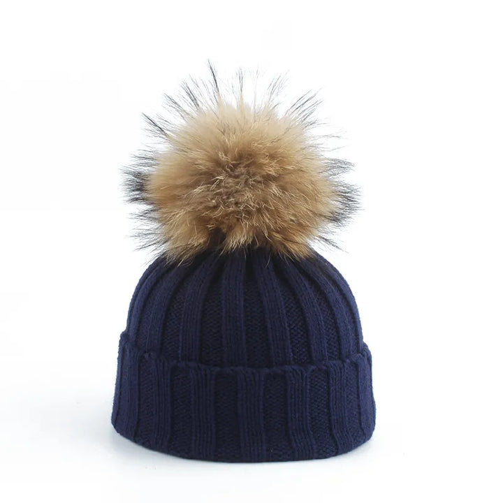 Dunkelblaue Strickmütze mit Kunstfellbommel, Wintermode, warme Accessoires, Unisex-Design.