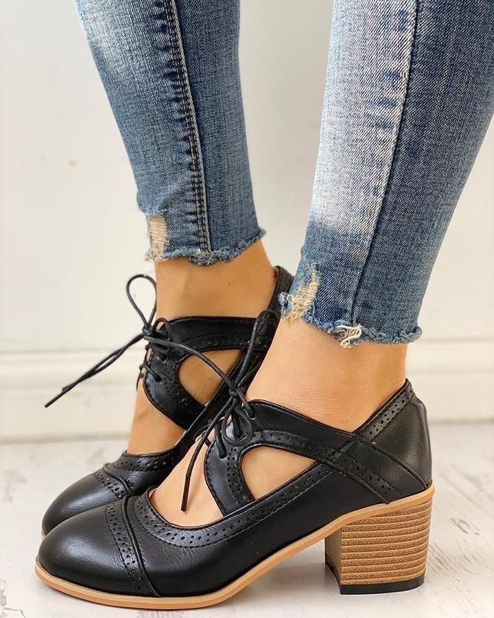 Schwarze Damen-Lederschnürschuhe mit Blockabsatz, getragen zu zerrissenen Jeans.