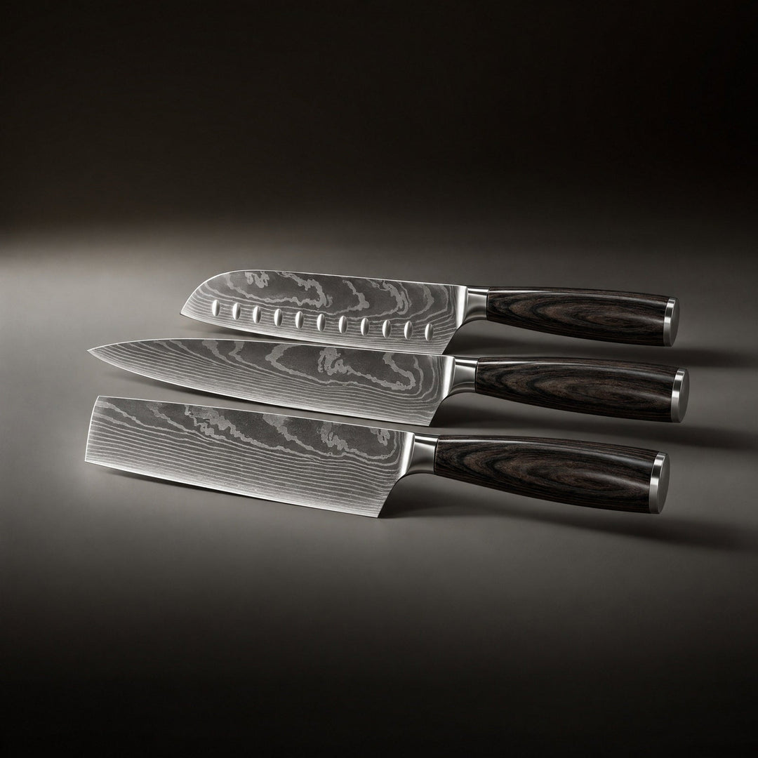 Tři nože ležící vedle sebe, shora santoku s důlky, kuchařský nůž a nůž s širokou obdélnou čepelí. 2