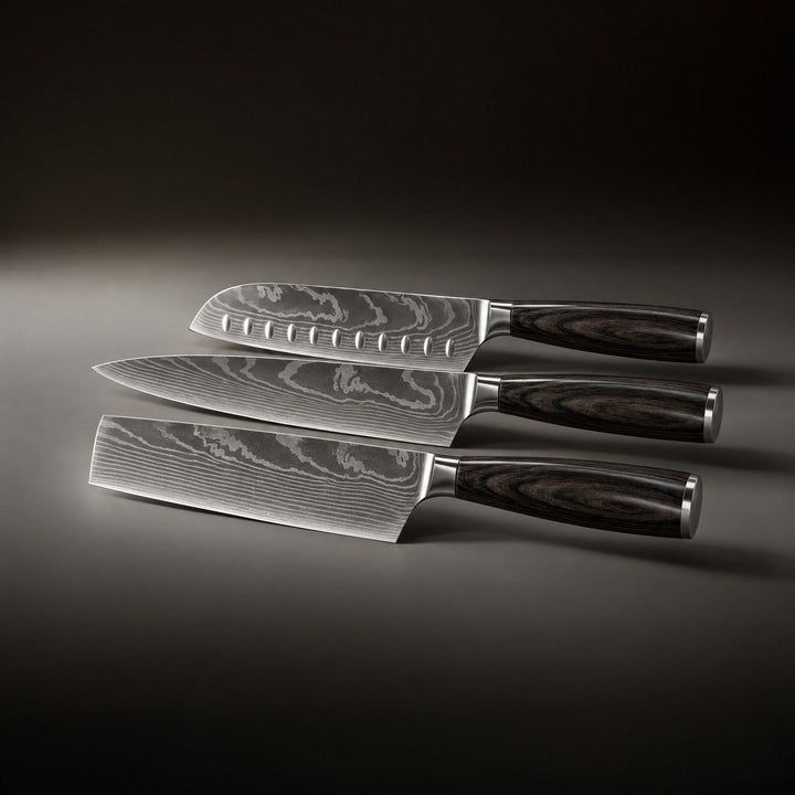 Tři nože ležící vedle sebe, shora santoku s důlky, kuchařský nůž a nůž s širokou obdélnou čepelí. 2