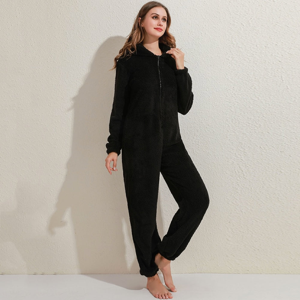 Frau in schwarzem Fleece-Overall, gemütlicher Einteiler, Reißverschluss, Freizeitkleidung.