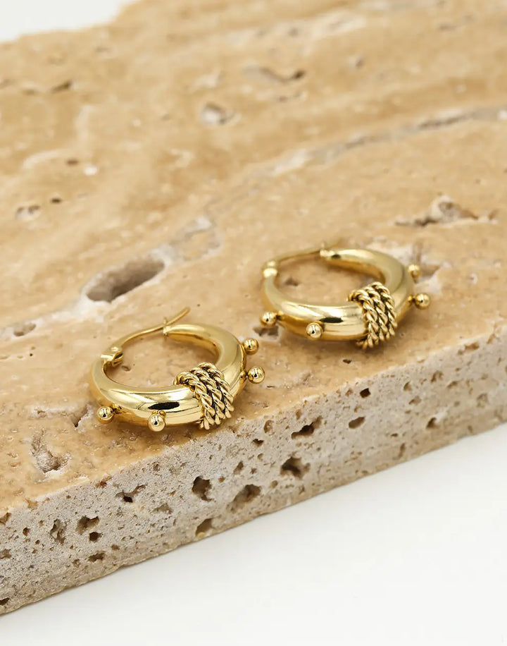 Goldene Chunky Bali Creolen auf Stein, modische Ohrringe, Schmuckaccessoire, Damenmode.