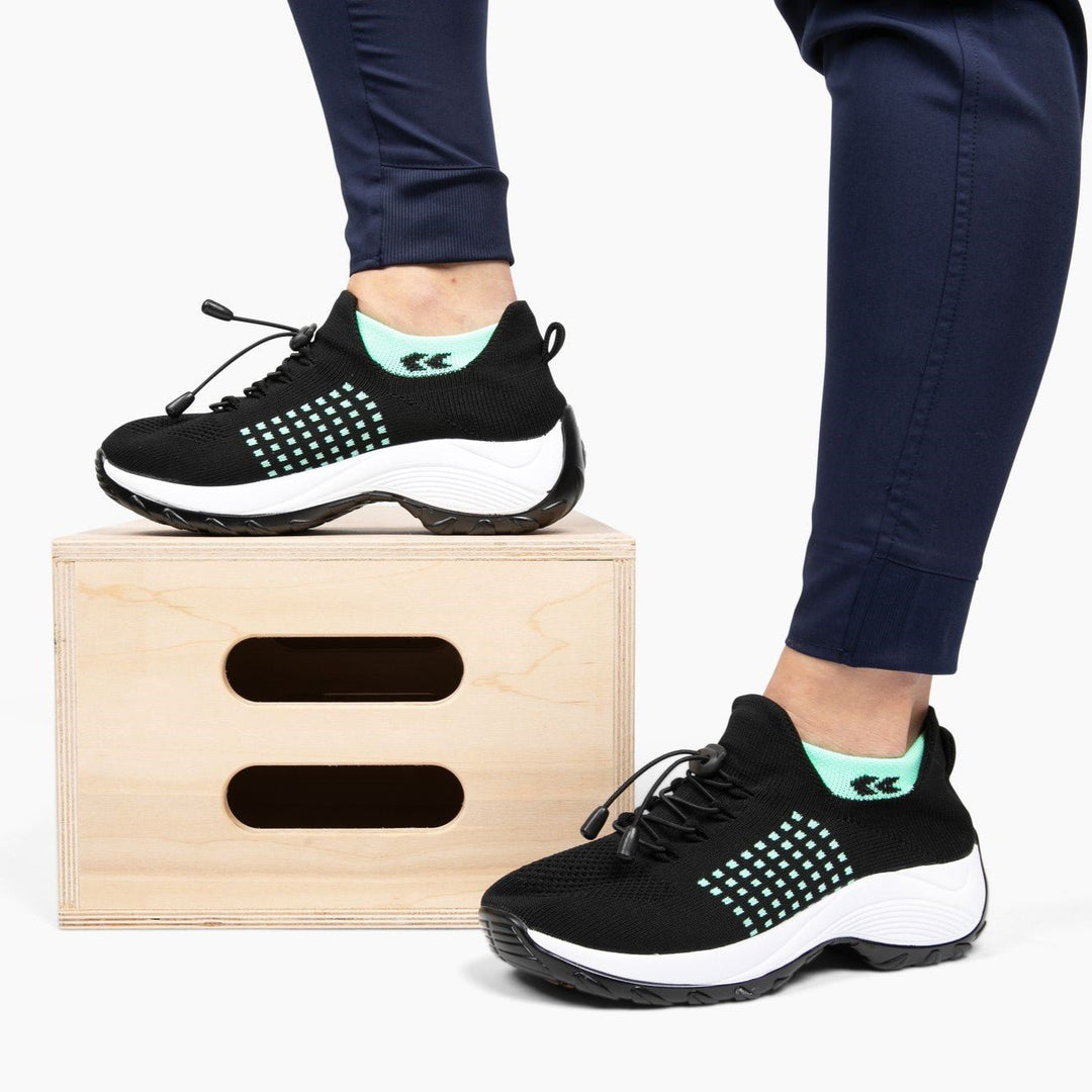 Schwarze orthopädische Stretch-Schuhe mit weißer Sohle, ideal für Komfort und Unterstützung.