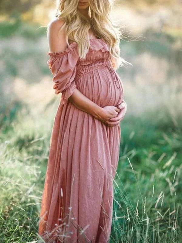 Schwangere Frau in rosa Maxikleid, Off-Shoulder, im Freien, Sommermode, natürliche Umgebung.