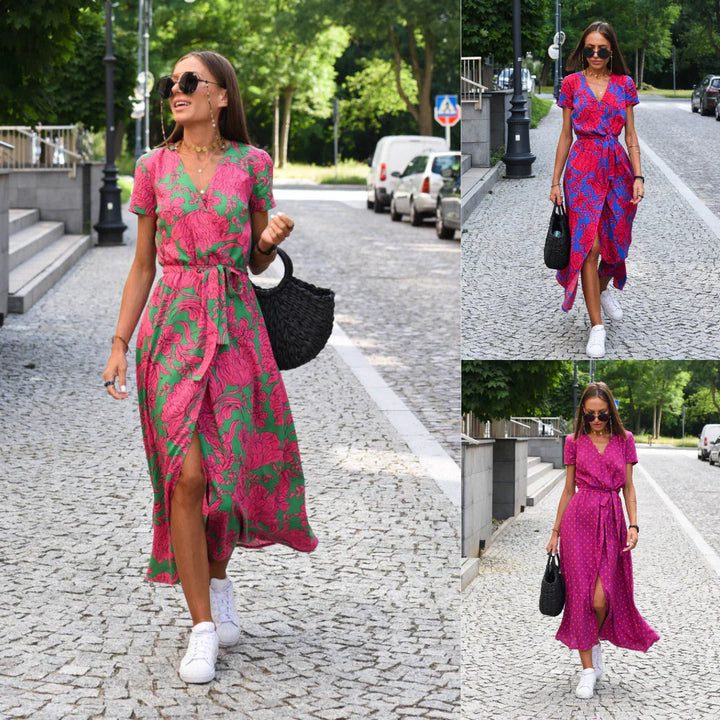 Frau in pink-grünem Sommerkleid, trägt schwarze Tasche, weiße Sneaker, läuft auf Kopfsteinpflaster.