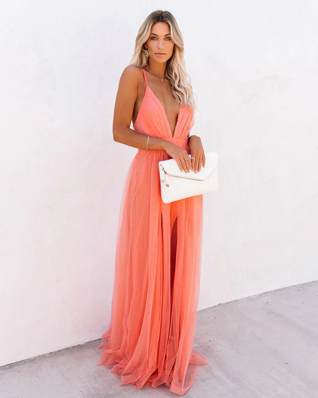 Frau in apricotfarbenem Maxikleid, elegantes Abendkleid, ärmellos, tiefer Ausschnitt, Sommermode.